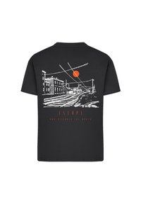Schwarzes T-Shirt mit weißem Linientext eines Gleisverlaufs, Gebäuden und Oberleitungsdrähte, mit einem roten Kreis und dem Text "FLIEHEN UND DIE WELT ENTDECKEN."
