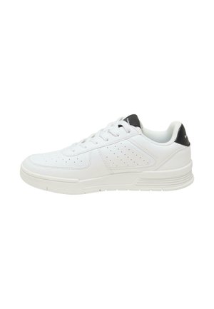 Chaussure de sport blanche avec une tige en cuir lisse, des détails perforés et un accent noir sur le talon. Semelle en caoutchouc épaisse pour le soutien.
