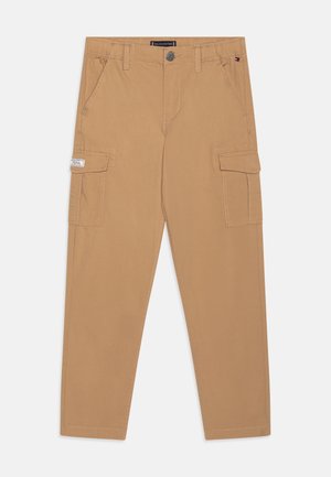 Beige cargobroek met zijzakken, schuine voorzakken, riemlussen, knoopsluiting en een klein logoplaatje op de rechterzak.