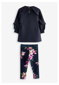 Abito in felpa blu navy con dettagli a balze e due bottoni sul retro, abbinato a leggings blu navy con grande motivo floreale rosa.