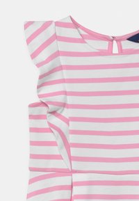 Sukienka w pasy w białe i różowe poziome paski, z falbaniastymi zdobieniami na ramionach oraz okrągłym dekoltem z zapięciem na guzik z tyłu.