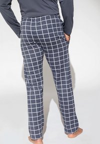 Granatowe piżamowe spodnie w kratę z białym wzorem w siatkę, z elastycznym pasem i kieszeniami bocznymi, wykonane z miękkiego, oddychającego materiału.