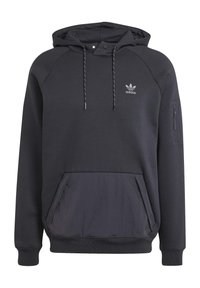 Svart huvtröja med dragsnodd i huvan, ribbade ärmar och en främre ficka. Har en ficka med dragkedja på ärmen och en liten logotyp på bröstet.