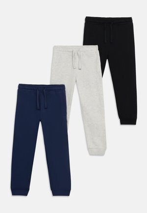 Drie paar kinderstretbroeken in marineblauw, lichtgrijs en zwart met trekkoord in de taille en omgeslagen enkels, overlappend gerangschikt.