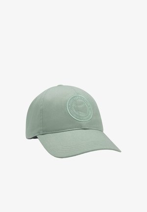 Vaaleanvihreä puuvillalippis, jossa on pyöreä kruunu ja kaareva lippa. Edessä on pyöreä logoplässi, jossa on teksturoidun pinnan omaava kuvio.