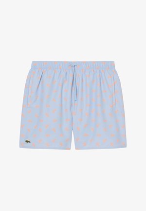 Pantaloncini azzurri chiaro con motivi di coccodrilli rosa, vita elastica con coulisse, tasche laterali e piccolo logo coccodrillo verde in basso a sinistra.