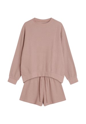 Pale pink waffle-knit loungewear set featuring a long-sleeve top with a crew neck and matching shorts with an elastic waistband and drawstring.