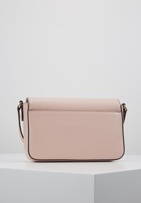 Růžová kožená crossbody taška s hladkým povrchem, obdélníkovým tvarem, zaoblenými hranami a zlatými akcenty.