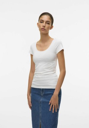 T-shirt bianco aderente a maniche corte con scollatura a girocollo, abbinato a una gonna di jeans di lunghezza media con uno spacco frontale.