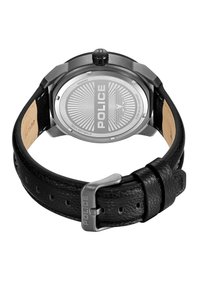 Svart läderremklocka med ett hölje i rostfritt stål, silverfärgad baksida som visar varumärket "POLICE" och en solstrålemönster.