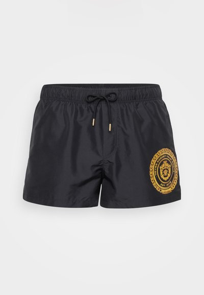 Jūras zila peldēšanas šortos ar elastīgu jostasvīru, auklu un zelta izšuvuma logotipa plāksni ar apļa dizainu. Viegls audums.
