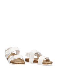 Sandalias blancas con correas entrecruzadas, plantilla de corcho y suela texturizada blanca. Cuenta con una hebilla ajustable para un ajuste seguro.