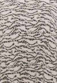 Tessuto chiaro con un motivo astratto ondulato in nero e marrone, caratterizzato da una superficie morbida e un design sottile e lineare.