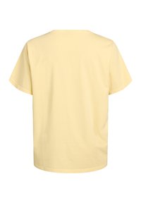 Camiseta de algodón amarillo claro con un corte holgado, mangas cortas y escote redondo. Diseño simple sin gráficos ni patrones visibles.