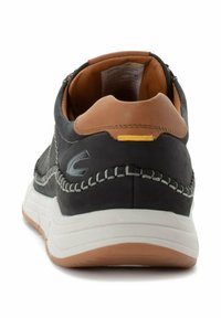 Schwarze Leder-Sneaker mit braunen Akzenten, ausgestattet mit einer weißen Zwischensohle und texturiertem Stich entlang des Obermaterials. Enthält ein kleines gelbes Detail.