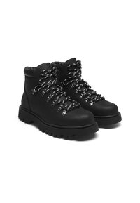 Black leather hiking boots with a rounded toe, chunky sole, and contrasting laces. Features silver hardware and padded ankle support.