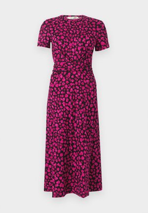 Vestido de manga curta feito de tecido macio, com fundo roxo escuro e padrões florais cor de rosa. Detalhe de nó na cintura que realça a forma.