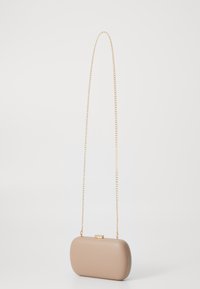 Bolso de mano rígido beige con cadena de oro, de forma rectangular redondeada, textura lisa y cierre de clic metálico.