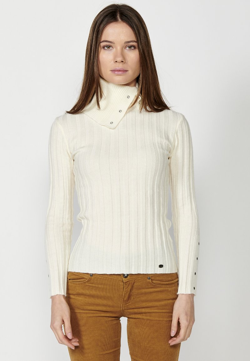 Weißer gerippter Rollkragenpullover mit umklappbarem Kragen, der Druckknopfakzente am Kragen und an den Bündchen aufweist. Enganliegendes Design.