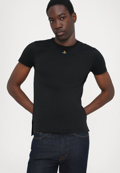 Tricou negru cu mânecă scurtă, realizat dintr-un material moale, având un mic emblema colorată pe piept și fante laterale la tiv pentru un plus de stil.