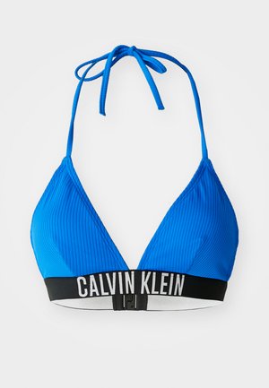 Haut de bikini triangle bleu à côtes avec liens ajustables, doté d'une bande noire avec le texte "CALVIN KLEIN" et d'une fermeture à clip dans le dos.