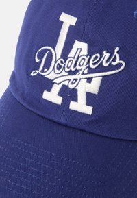 Plava Dodgers bejzbol kapa napravljena od pamuka. Ima izvezeni bijeli logo sprijeda. Zakrivljeni vizir, teksturirana tkanina i podesiva stražnja strana.