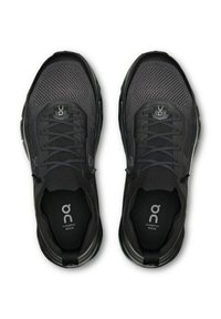 Par de zapatillas de running negras con cordones, parte superior de malla y marca "Cloudtilt Moon" en las plantillas.