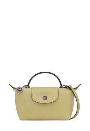 Small pastel yellow leather handbag with top handle, flap closure, and detachable shoulder strap against a white background.