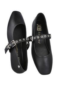 Bailarinas de cuero negro con punta redonda, que presentan una correa con ojales plateados y una hebilla. Textura suave y diseño minimalista.