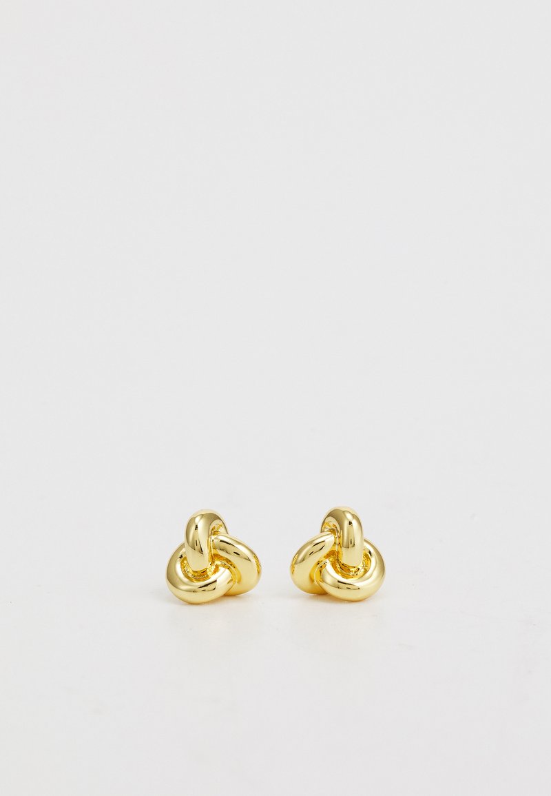 Naušnice od zlatnog tona s dizajnom u obliku uvrnute čvorove. Glatka površina, okrugli oblik i sjajna završna obrada za reflektivni izgled.