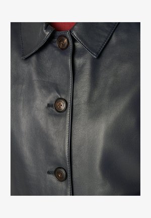 Manteau en cuir noir à l'avant avec trois boutons marron foncé et col pointu, montrant une texture lisse et des coutures cousues.