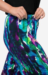 Flerfärgade joggerbyxor med ett livligt abstrakt mönster i lila, grönt och blått, med ett elastiskt midjeband för komfort.