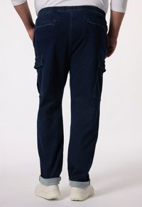 Granatowe dżinsowe spodnie cargo z elastycznym paskiem w talii, zrolowanymi mankietami i dwoma bocznymi kieszeniami. Prosty design z minimalnymi detalami przeszyć.