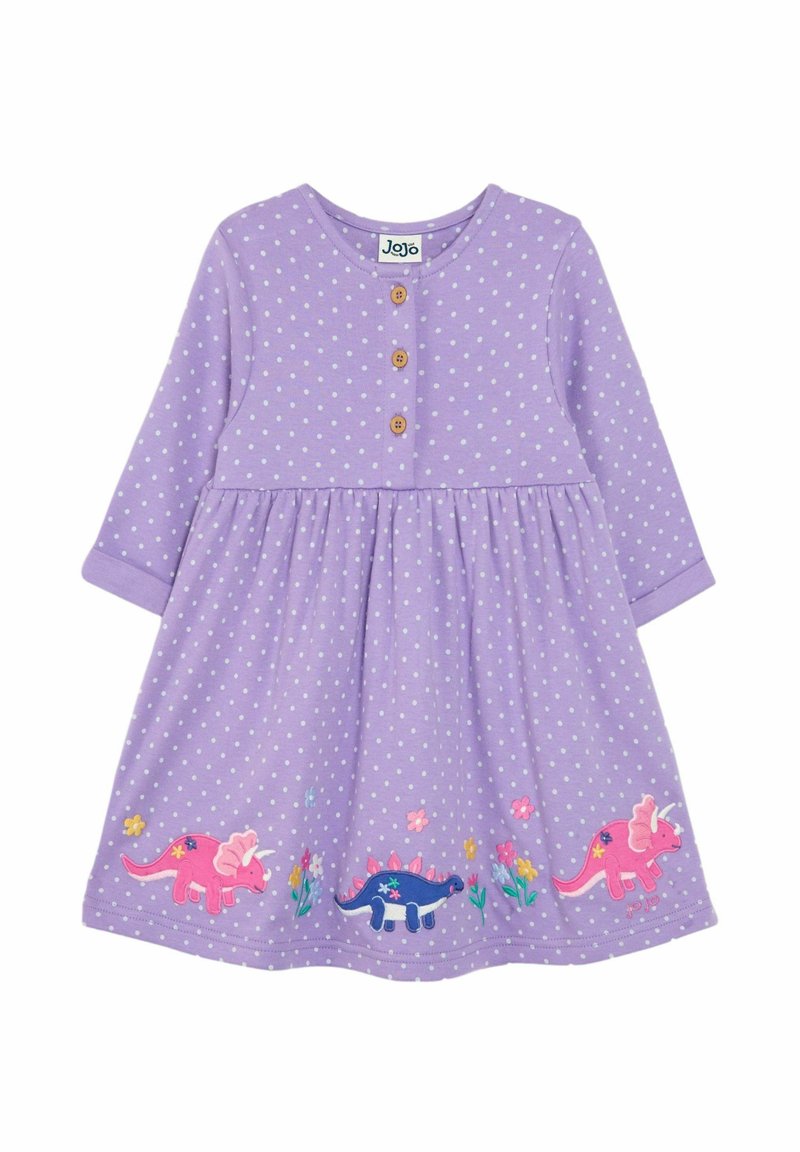 Fialové šaty s dlhým rukávom, biele bodky, drevené gombíky a farebná výšivka dinosaurov na okraji, so zátiším kvetov a zelene.