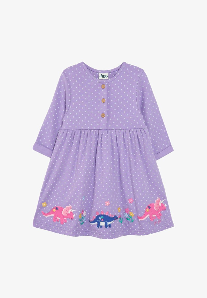 Fialové šaty s dlhým rukávom, biele bodky, drevené gombíky a farebná výšivka dinosaurov na okraji, so zátiším kvetov a zelene.