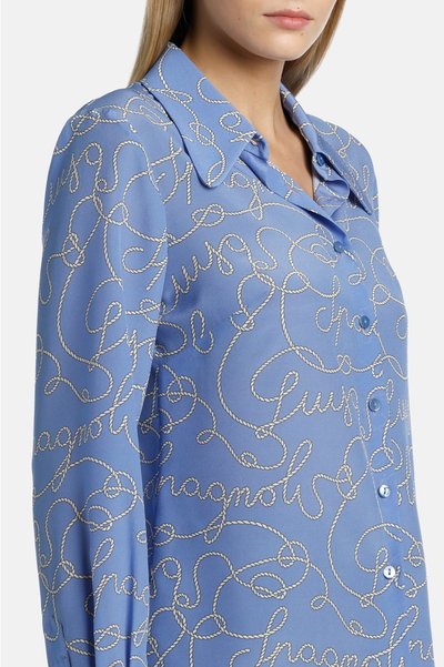 Blauwe zijden blouse met een subtiel touwpatroon in het wit, voorzien van een kraag en knoopsluiting, en een zachte textuur.