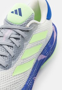 adidas Performance SUPERNOVA STRIDE - Silniční běžecké boty - off white/green spark/lucid blue