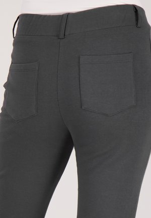 Grijze stoffen broek met een gladde textuur, voorzien van twee achterzakken met vierkante vormen en zichtbare stikseldetails.