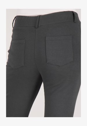 Grijze stoffen broek met een gladde textuur, voorzien van twee achterzakken met vierkante vormen en zichtbare stikseldetails.