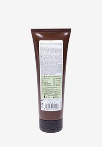 Brun tube med ett svart lock, med en vit och grön etikett som innehåller produktinformation, ingredienser och bruksanvisningar.