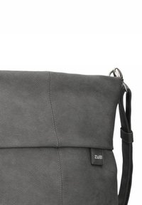 Bolso mensajero de cuero gris con solapa plegable, textura suave, correa ajustable y una sutil etiqueta de logo en el lateral.