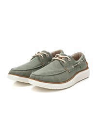 Zapatos de tela verdes con suelas blancas, puntera redonda y cordones beige. Presentan una superficie texturizada y acentos marrones contrastantes.