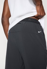 Αθλητικές βερμούδες Nike σε μαύρο με ομαλή υφή. Διαθέτουν ζώνη μέσης με το λογότυπο "All Conditions" και μια διακριτική πίσω τσέπη.