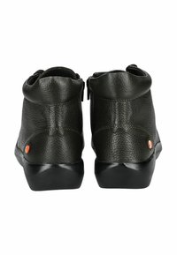 Botines de cuero verde oliva con superficie texturizada, collar redondeado, suela de goma negra y un acento naranja en el lateral.