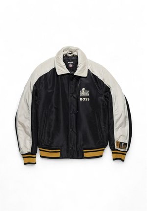 Giacca bomber in satin nera e grigia con chiusura a bottoni, polsini a costine, dettagli dorati e logo sul petto e sulla manica.