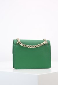 Borsa a tracolla verde in pelle, forma rettangolare, superficie texturizzata e design minimalista. Presenta una chiusura a pattina.