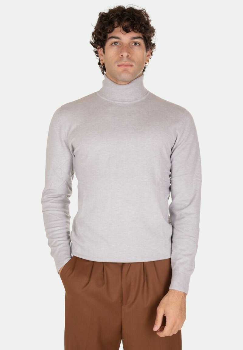 Maglione a collo alto grigio chiaro realizzato in morbido tessuto a maglia, con maniche lunghe e design aderente, abbinato a pantaloni marroni.