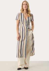 Robe à rayures à manches courtes avec un col en V plongeant et une silhouette fluide dans des couleurs pastel sur un fond clair.