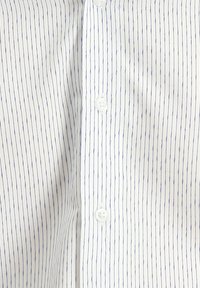 Witte shirt met verticale blauwe streepjes, met een kraag en witte knopen aan de voorkant. Glad textuur en lichtgewicht stof.