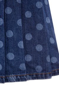 Tessuto in denim con una base blu scuro, caratterizzato da pois blu chiaro. La texture è liscia con una leggera lucentezza. Cuciture visibili in arancione.